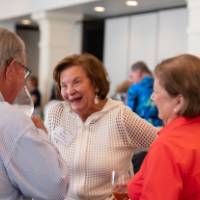 Pat Waring talking with a gentleman and woman standing in a circle